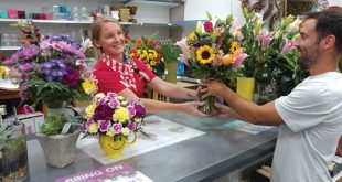 Woman at floral shop serving a customer